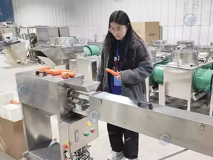 un ouvrier teste la machine à éplucher les carottes