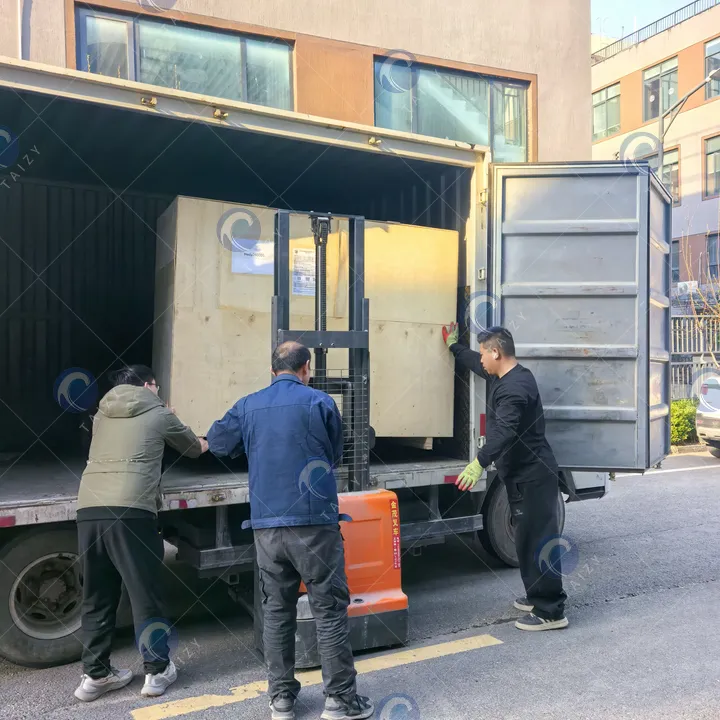 Загрузка машины для очистки в контейнер для доставки